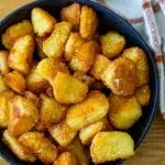 Top view of golden and crispy roast potatoes served in a bowl