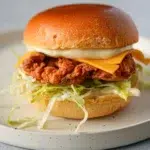 Southern fried chicken burger featuring a crispy fried chicken patty, lettuce, tomato, and pickles on a toasted bun