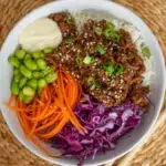 beef and vegetables in a glossy teriyaki sauce, garnished with sesame seeds and green onions.