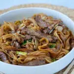 Delicious beef and rice noodles served in a bowl, topped with sliced beef