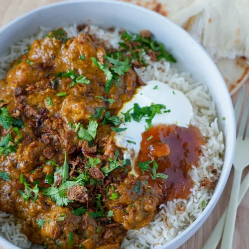 Quick coconut creamy chicken curry with tender chicken pieces, served with rice and a rich coconut sauce, garnished with fresh herbs