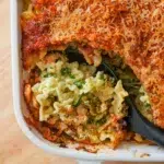 Close-up of a creamy spinach and cheese pasta bake, showcasing golden melted cheese and revealing the delicious filling inside.