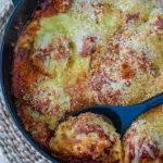 Close-up of a spoon scooping Chicken Meatball Parmigiana