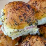 Close-up of baked ham and cheese sliders with a golden-brown top