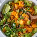 Close-up of a spoon scooping Mango Salad with Sweet Chilli Lime Dressing from a bowl