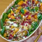 Freshly prepared roast pumpkin salad with creamy feta and crunchy candied walnuts in a bowl.