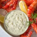 Tray of prawns served with a bowl of tartare sauce, ready for dipping.
