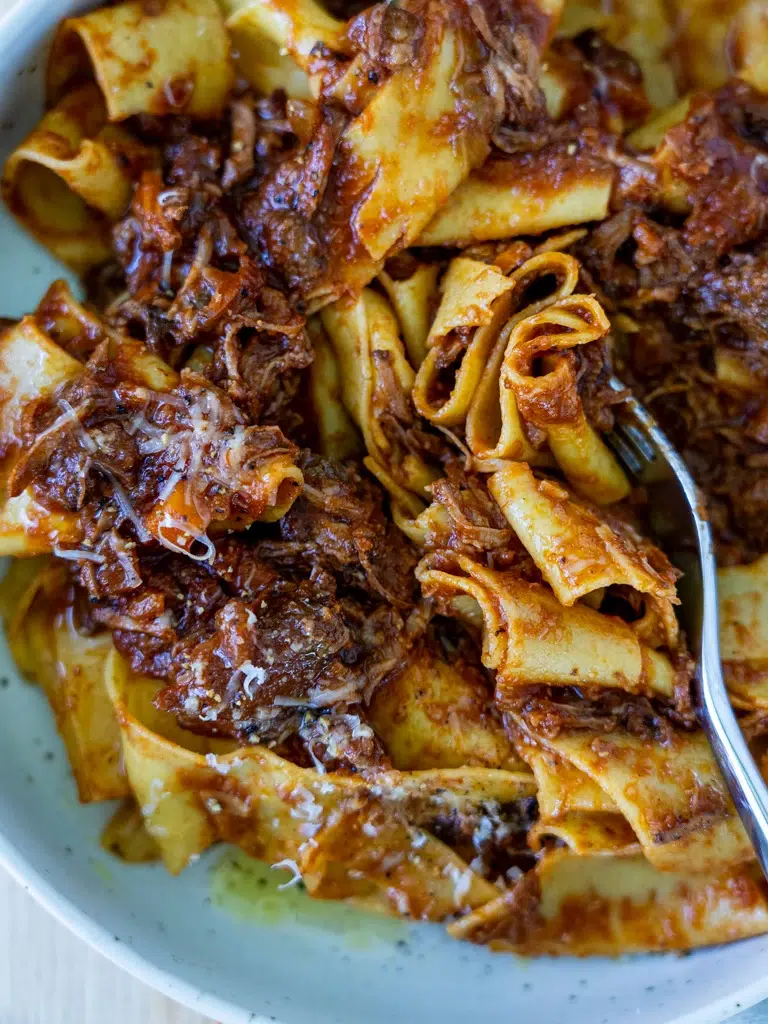 Hearty slow cooker beef ragu with a fork digging in.