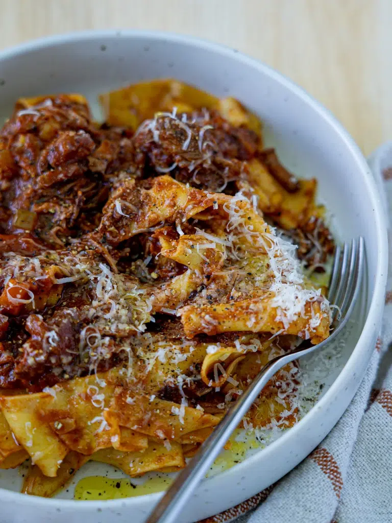 Close-up of slow cooker beef ragu with a fork ready to dig in.