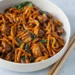 Close-up of a bowl of Three-Cup Chicken Noodles, featuring tender chicken, noodles, and a flavorful sauce.