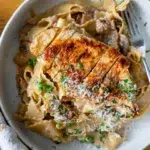 Top view of plated Chicken Boscaiola Pasta with creamy sauce, bacon, and mushrooms.