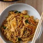 Chicken Lo Mein noodles plated in a bowl with chopsticks.