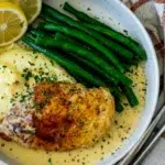 Top view of a plated Creamy Lemon Pepper Chicken served with green beans, mashed potatoes, and a rich sauce.