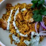 One-pan Tandoori Chicken and Rice – spiced chicken over fragrant rice, plated with a refreshing mint yogurt drizzle