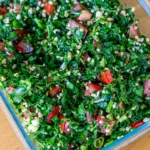Fresh tabouli salad with parsley, tomatoes, and bulgur stored in an airtight container.