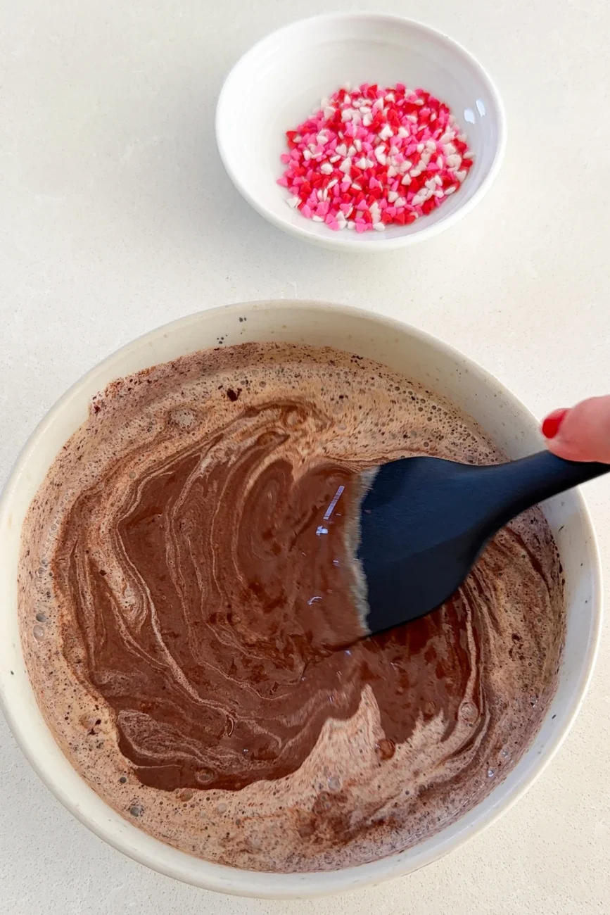 Making the chocolate ganache with hot cream and chocolate partially stirred together