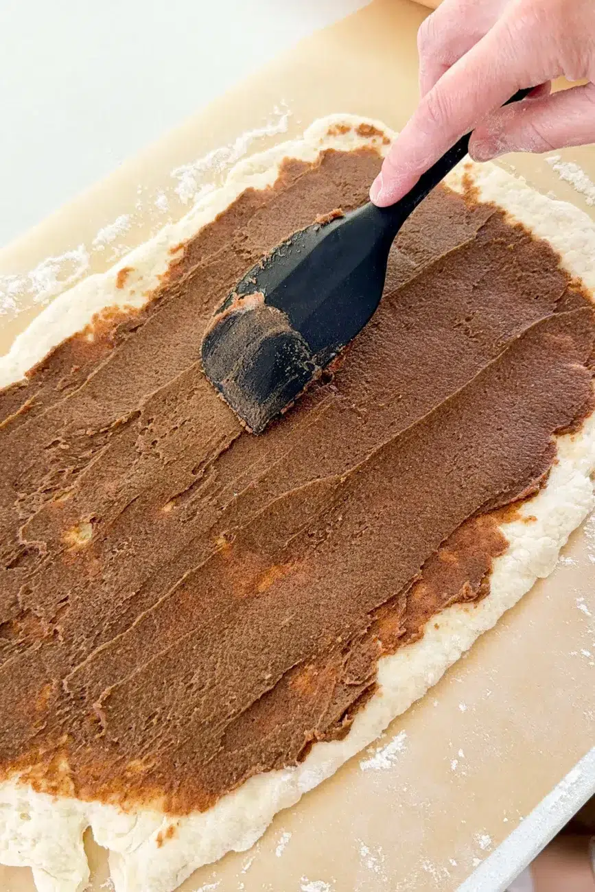 Cinnamon butter being spread onto dough