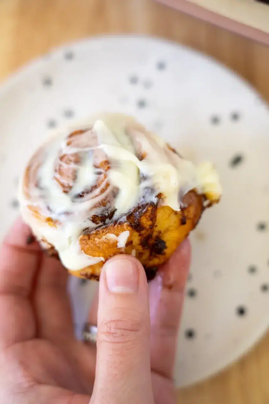 Easy no yeast cinnamon scroll being held close up