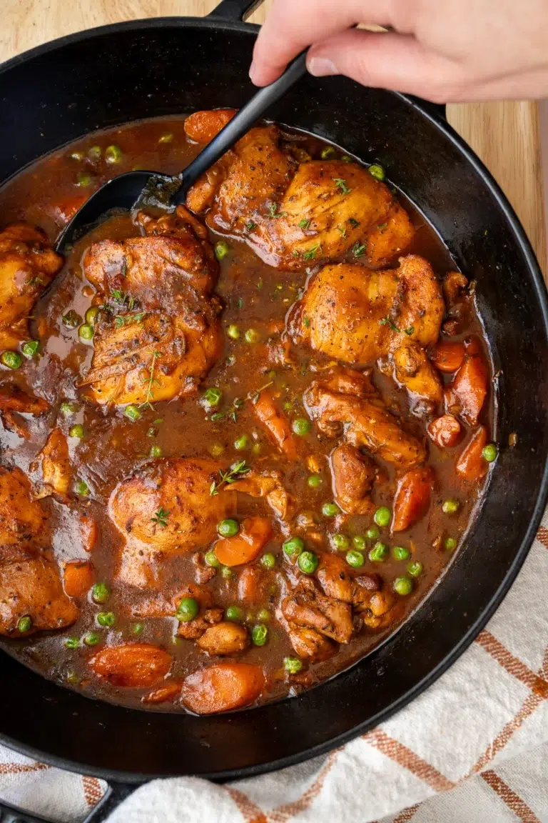 Finished chicken carrots and gravy in pan with spoon ready to be served