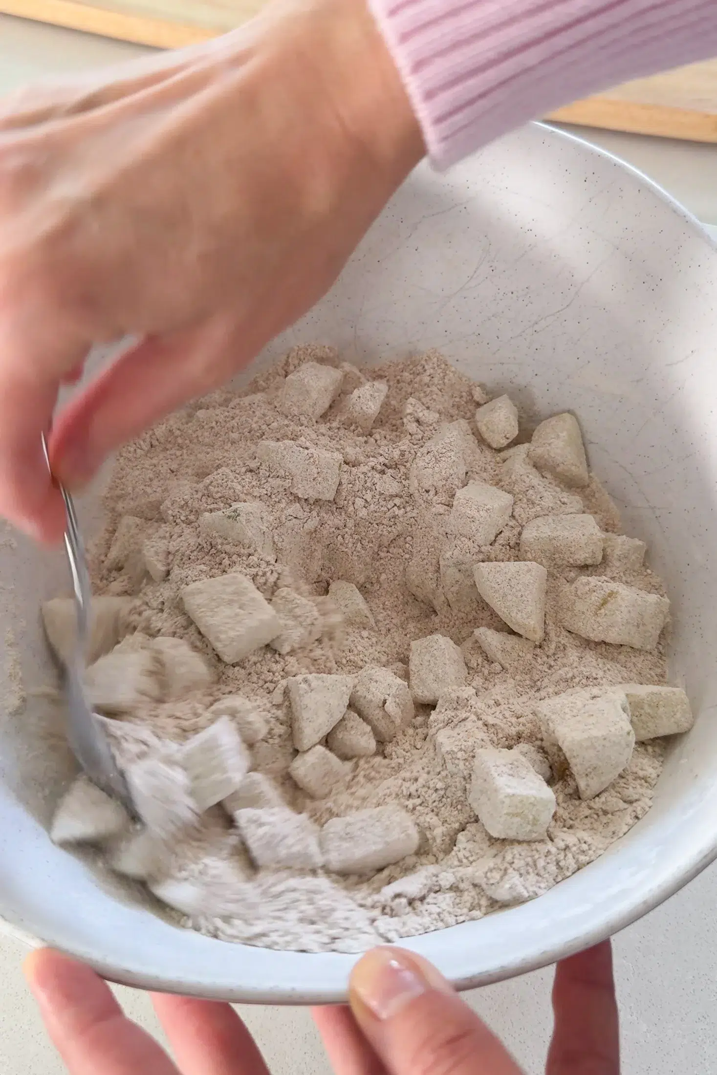 Apples being folded through the dry ingredients