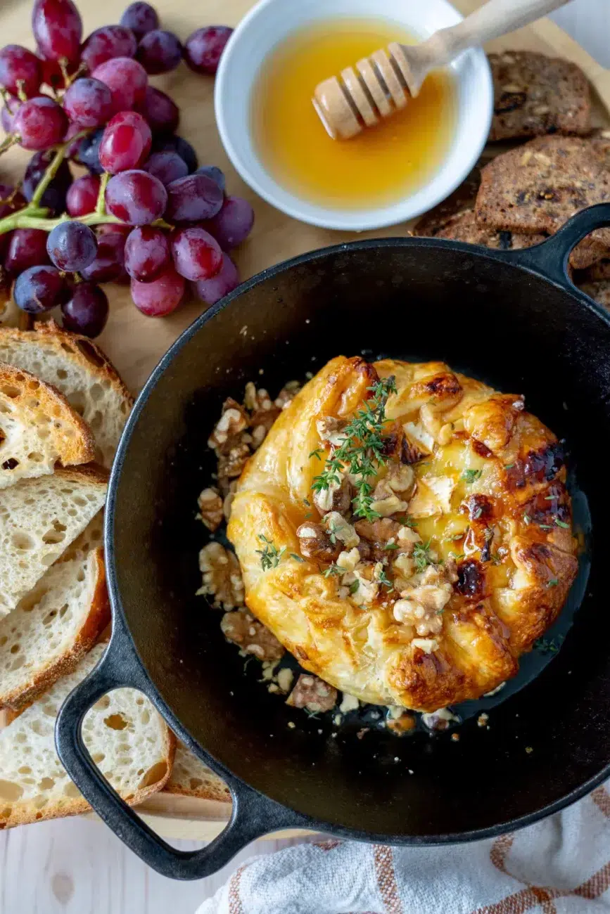 Baked Brie on platter with bread, grapes and honey