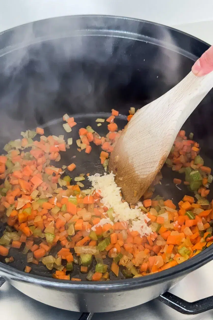 Garlic added to softened veggies in pan