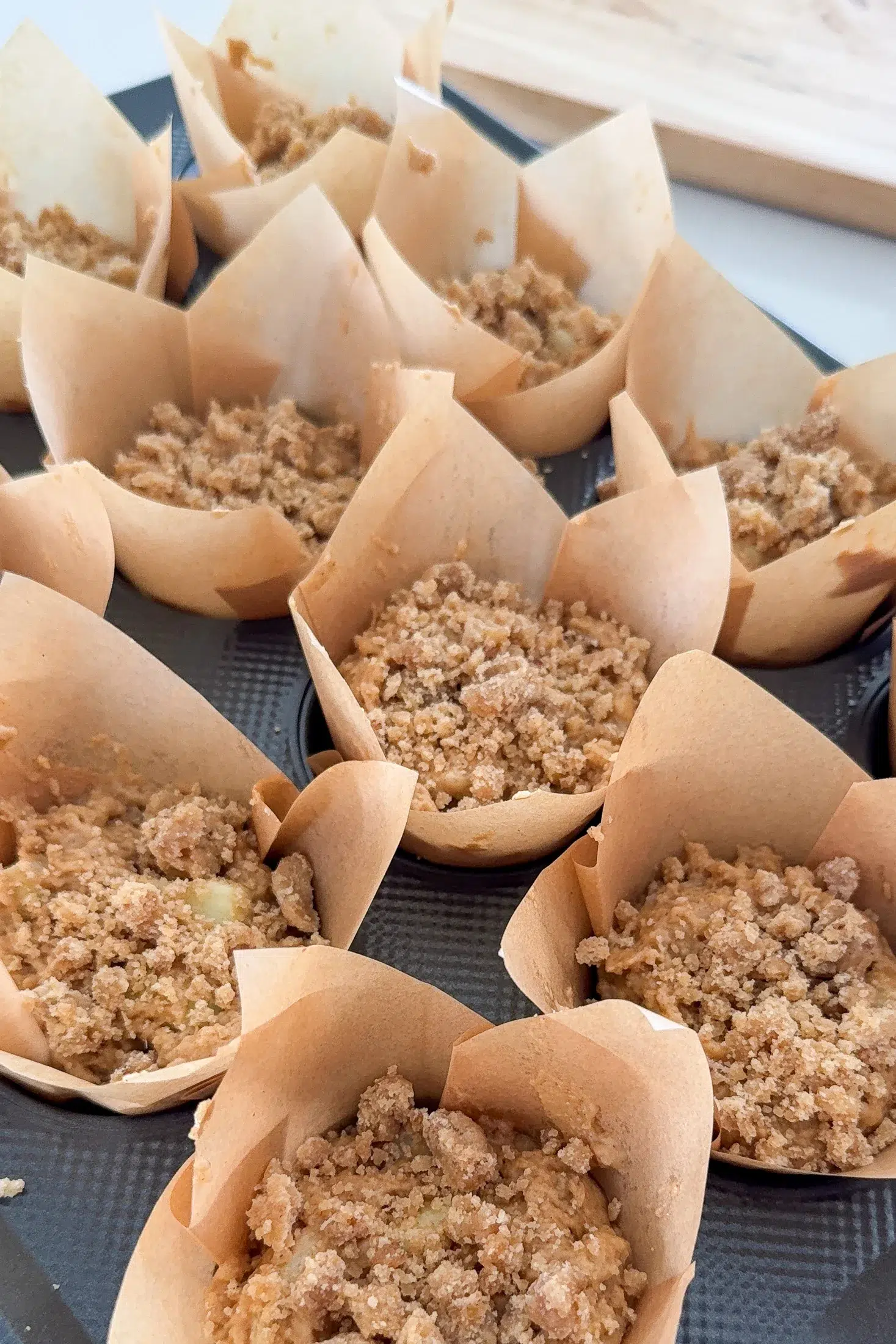 The muffins in their cases with crumble on top ready to be baked