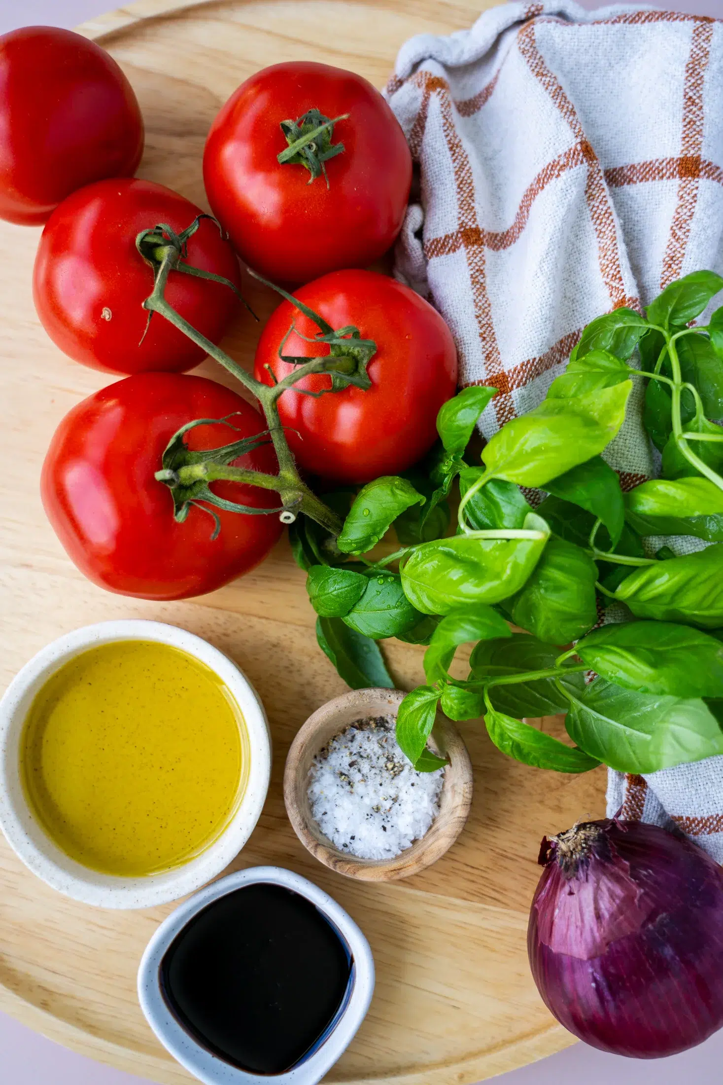 Fresh ingredients for bruschetta salad laid out on a bench