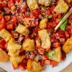 Bruschetta salad with crispy garlic parmesan croutons served with a spoon