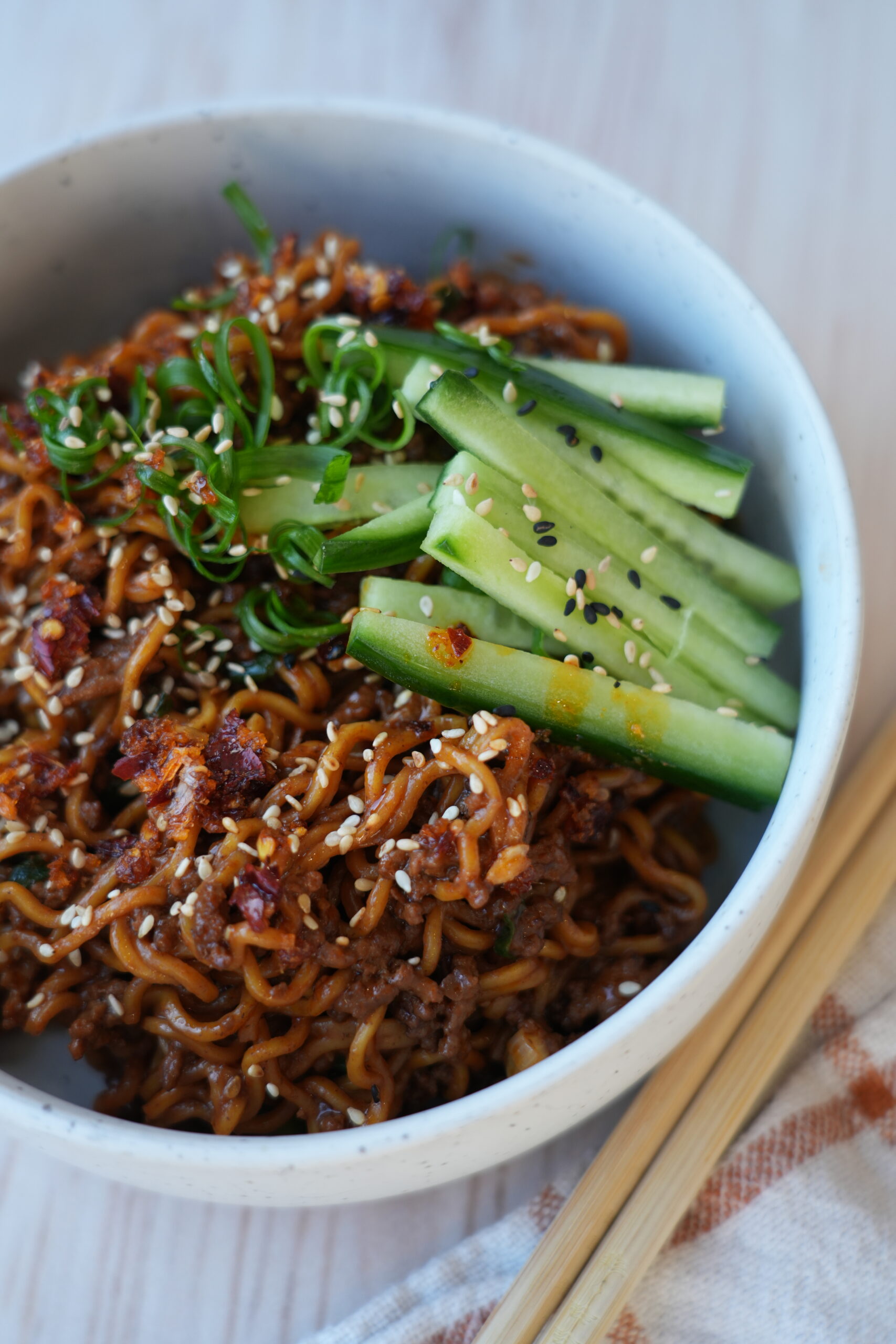 One-pan Korean-style beef noodles topped with sesame seeds, cucumber and spring onion