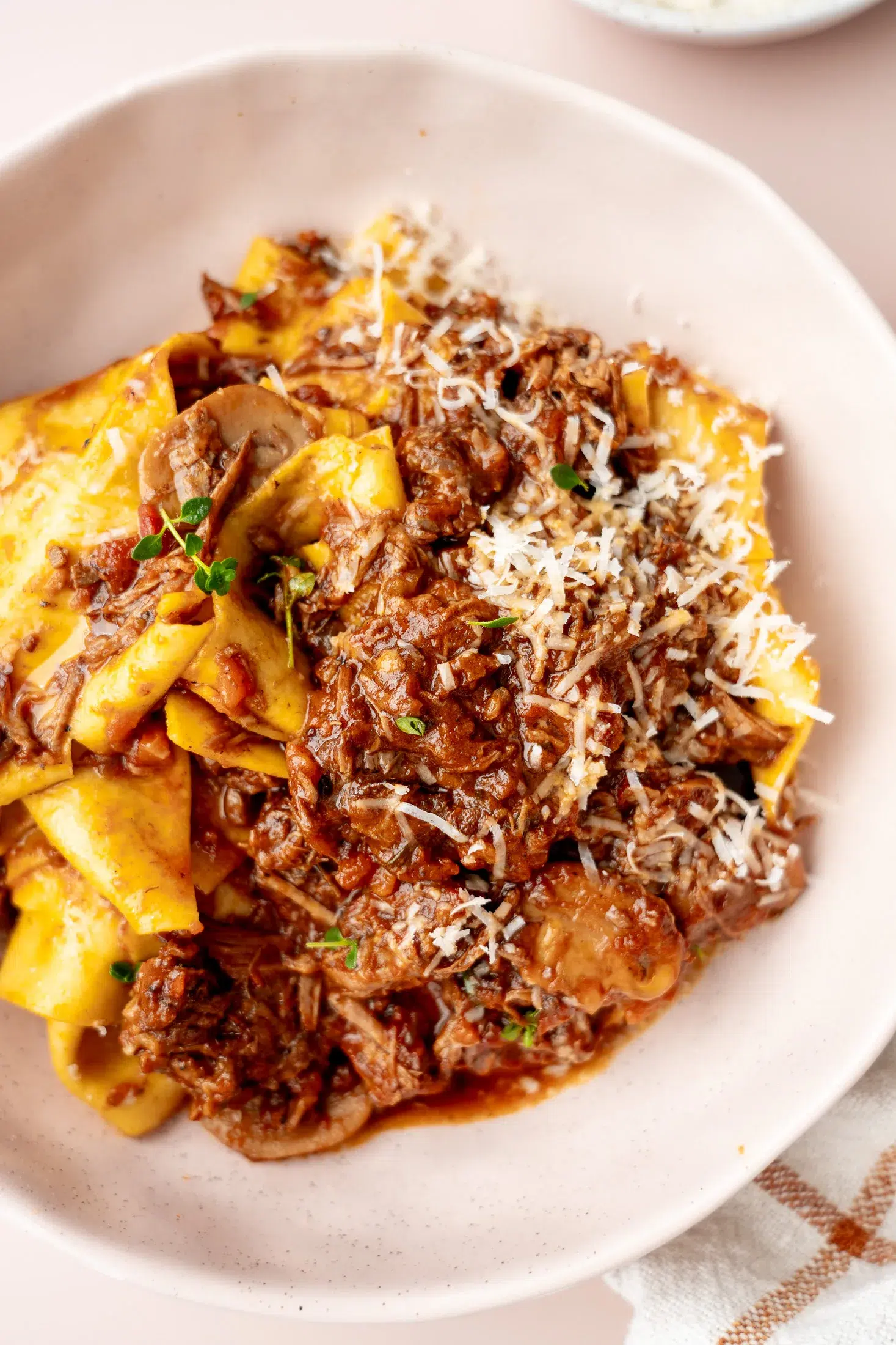 Close-up of tender shredded beef in slow-cooked mushroom ragu sauce