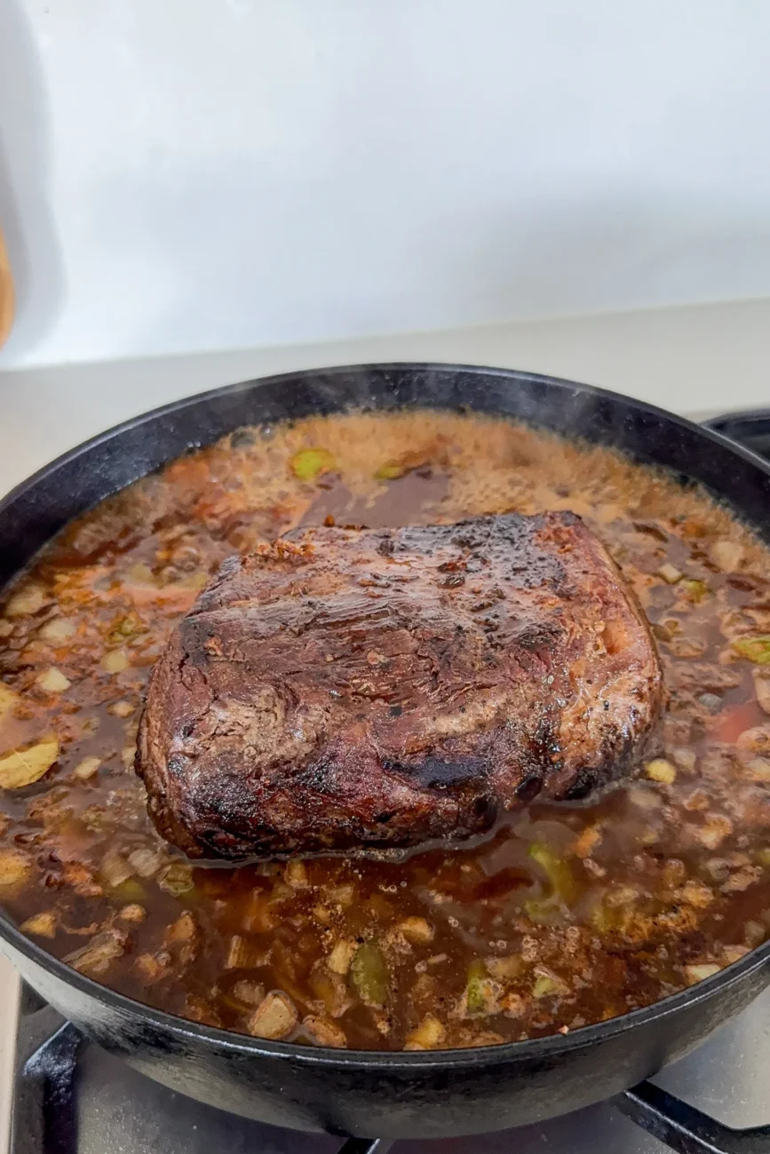 Chuck roast returned to pan with vegetables and gravy base