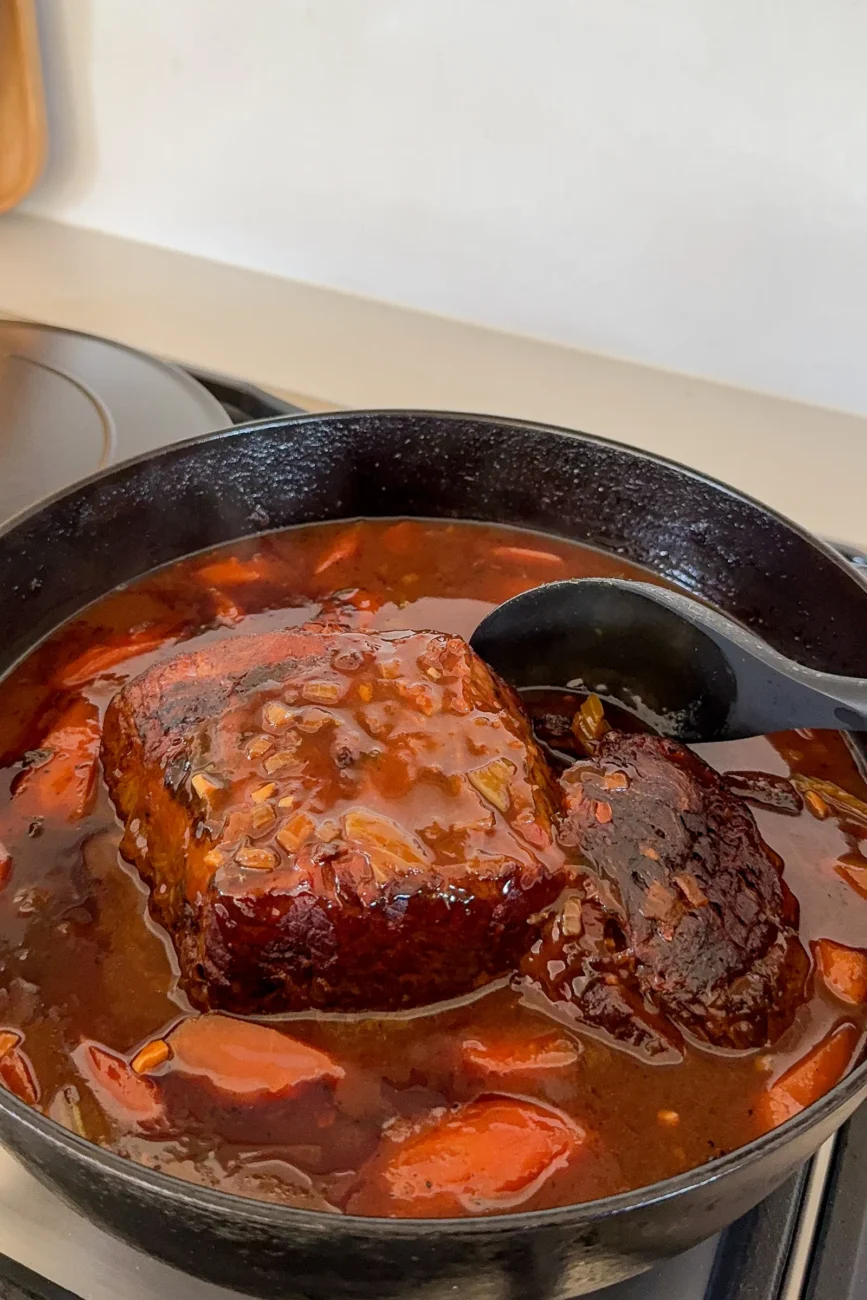 Finished pot roast with thick glossy gravy ready to be cut or shredded