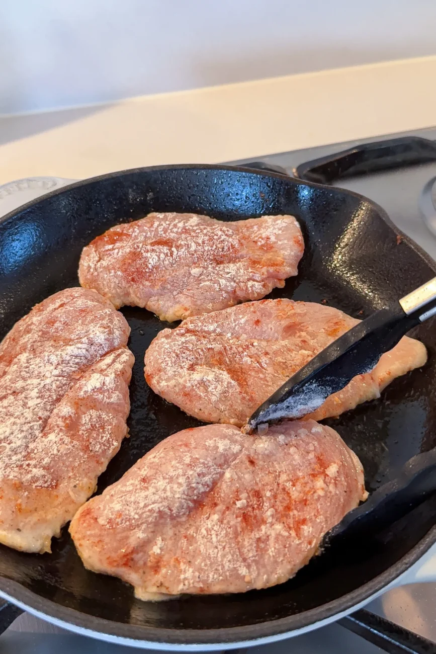 Floured Chicken Being Sealed in Pan
