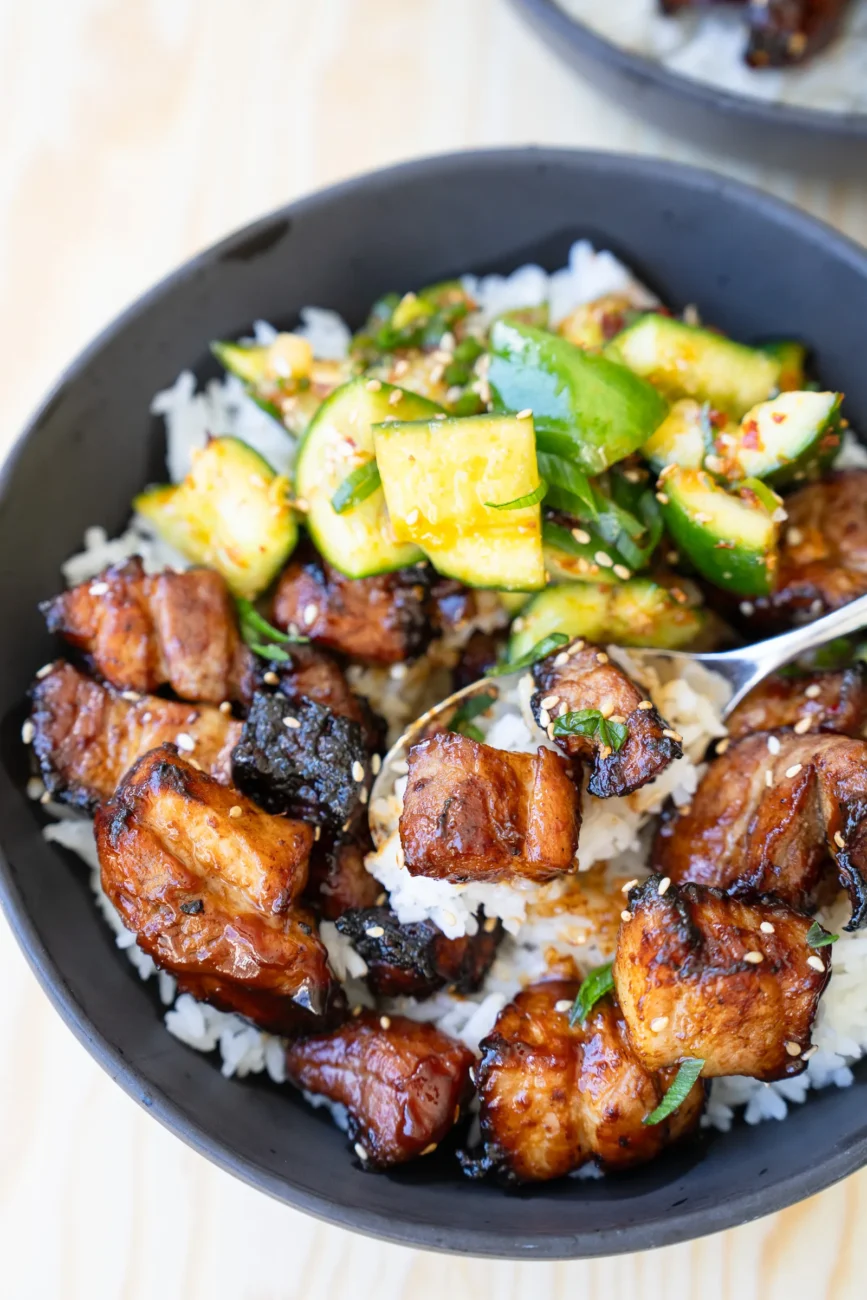 Overhead shot spoon digging into Pork belly bites