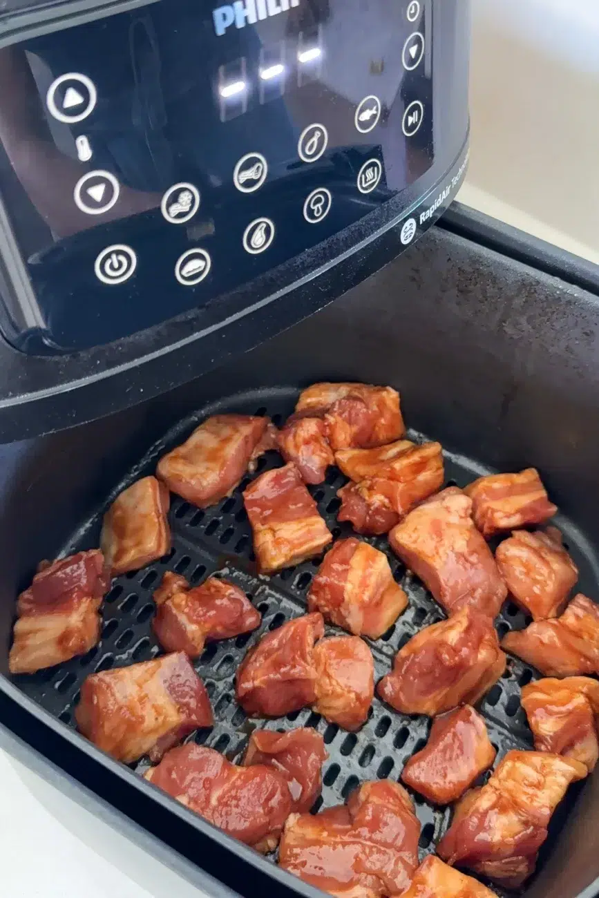 Pork arranged in air fryer ready to cook