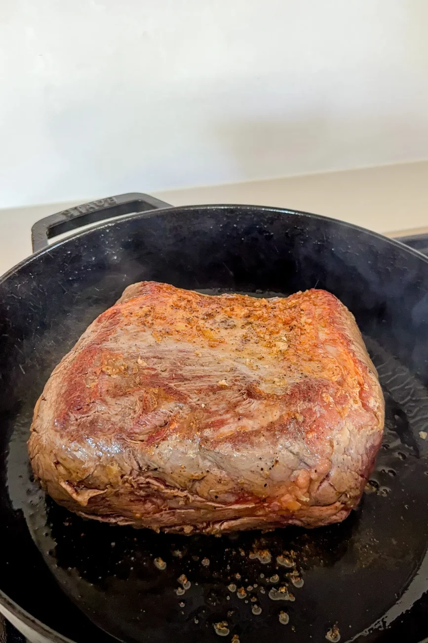 Raw chuck being seared turning golden and developing a crust