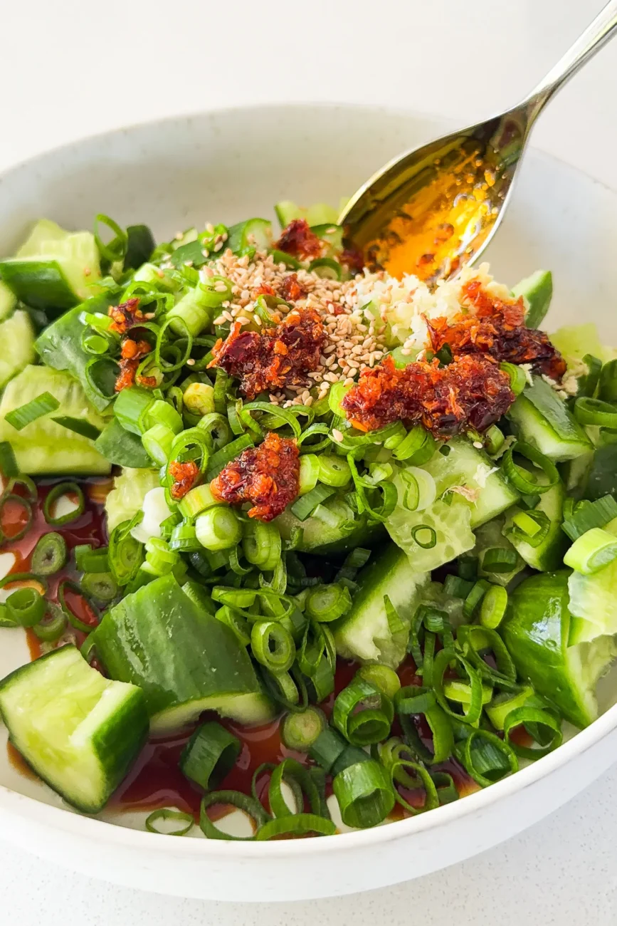 Smashed cucumber ingredients added in bowl ready for mixing