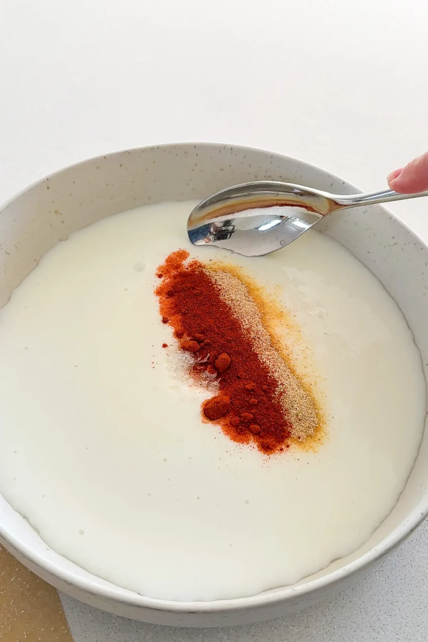 Spices added to buttermilk ready to be mixed in