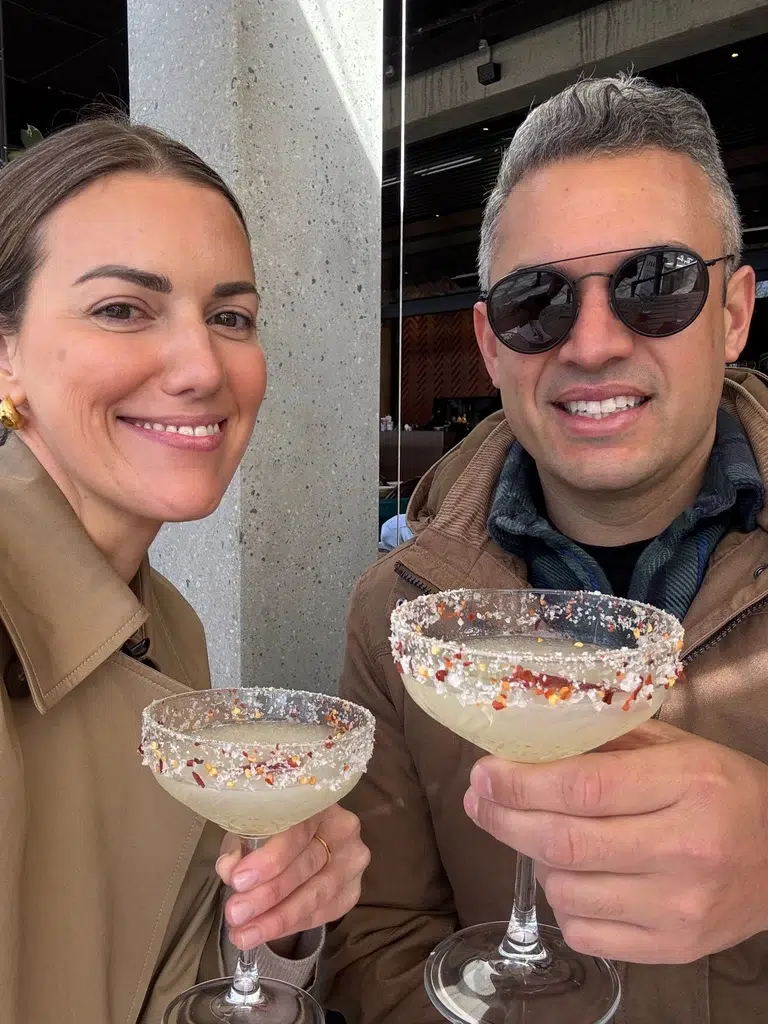 Nicole and Heath holding margaritas and smiling at the camera