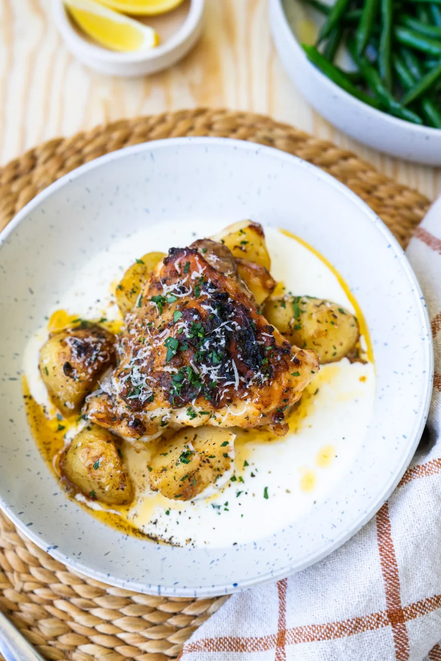 Chicken plated with sauce on the base of the shallow bowl