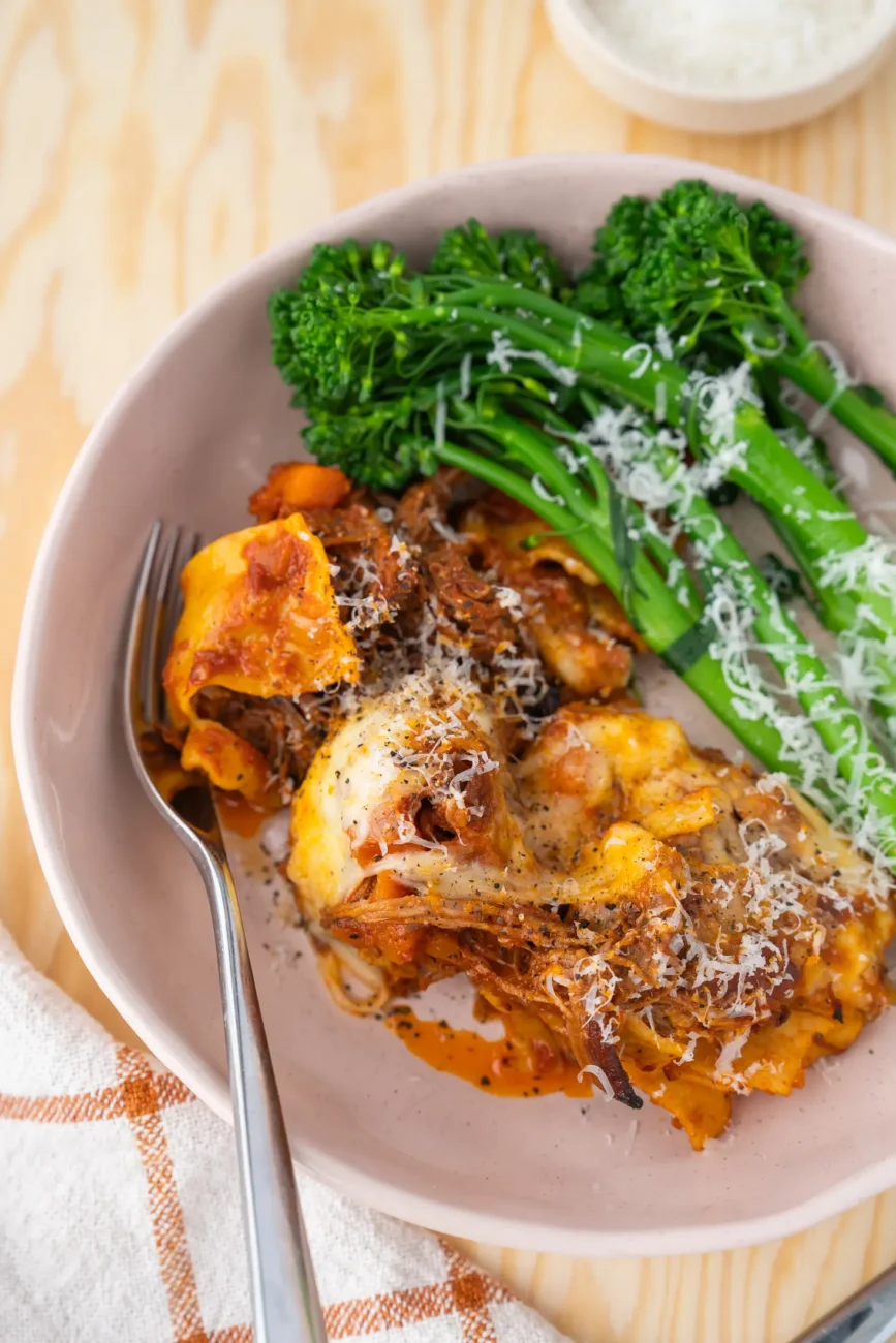 beef ragu lasagne served with broccolini