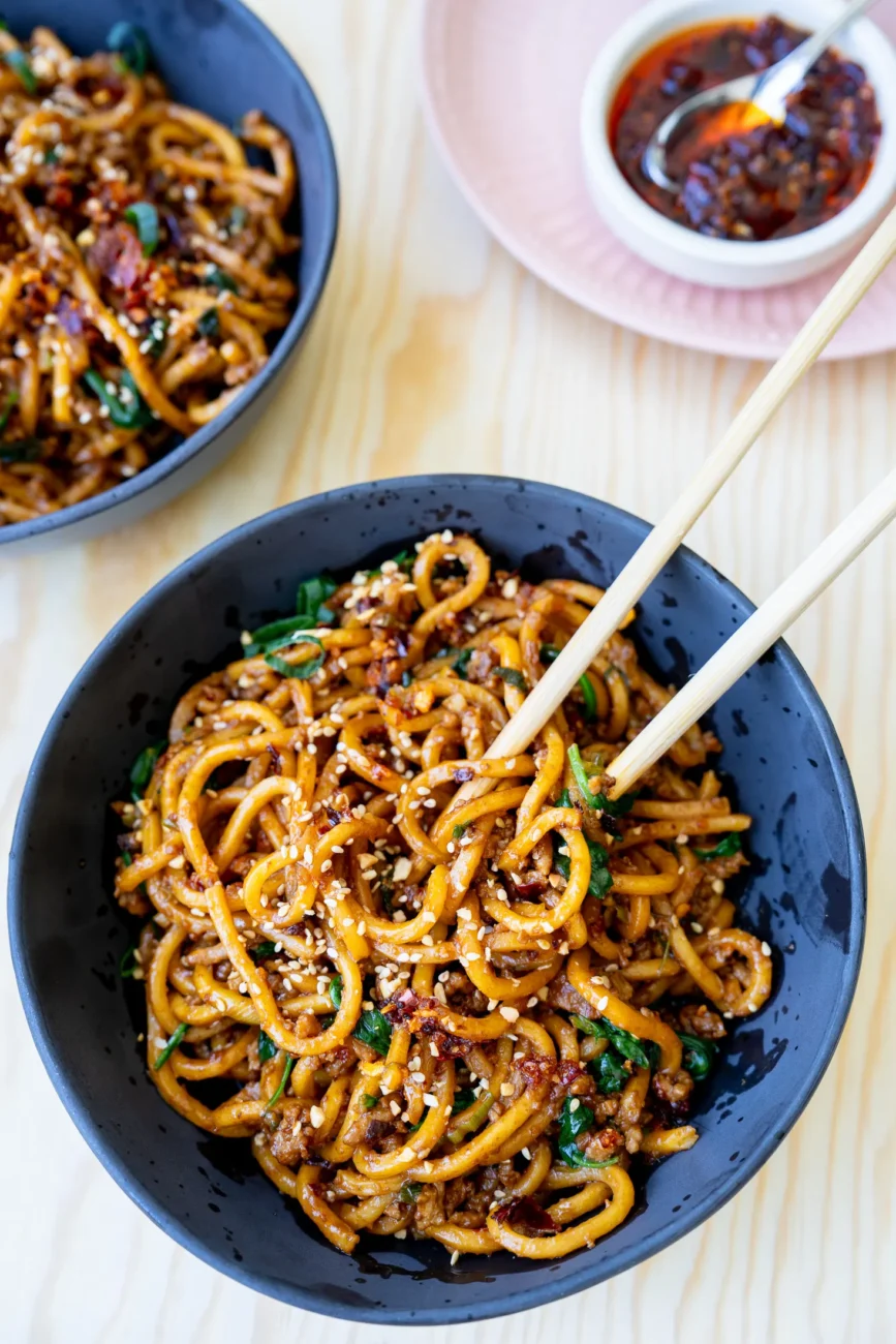 overhead dan dan noodles in bowl with chopsticks