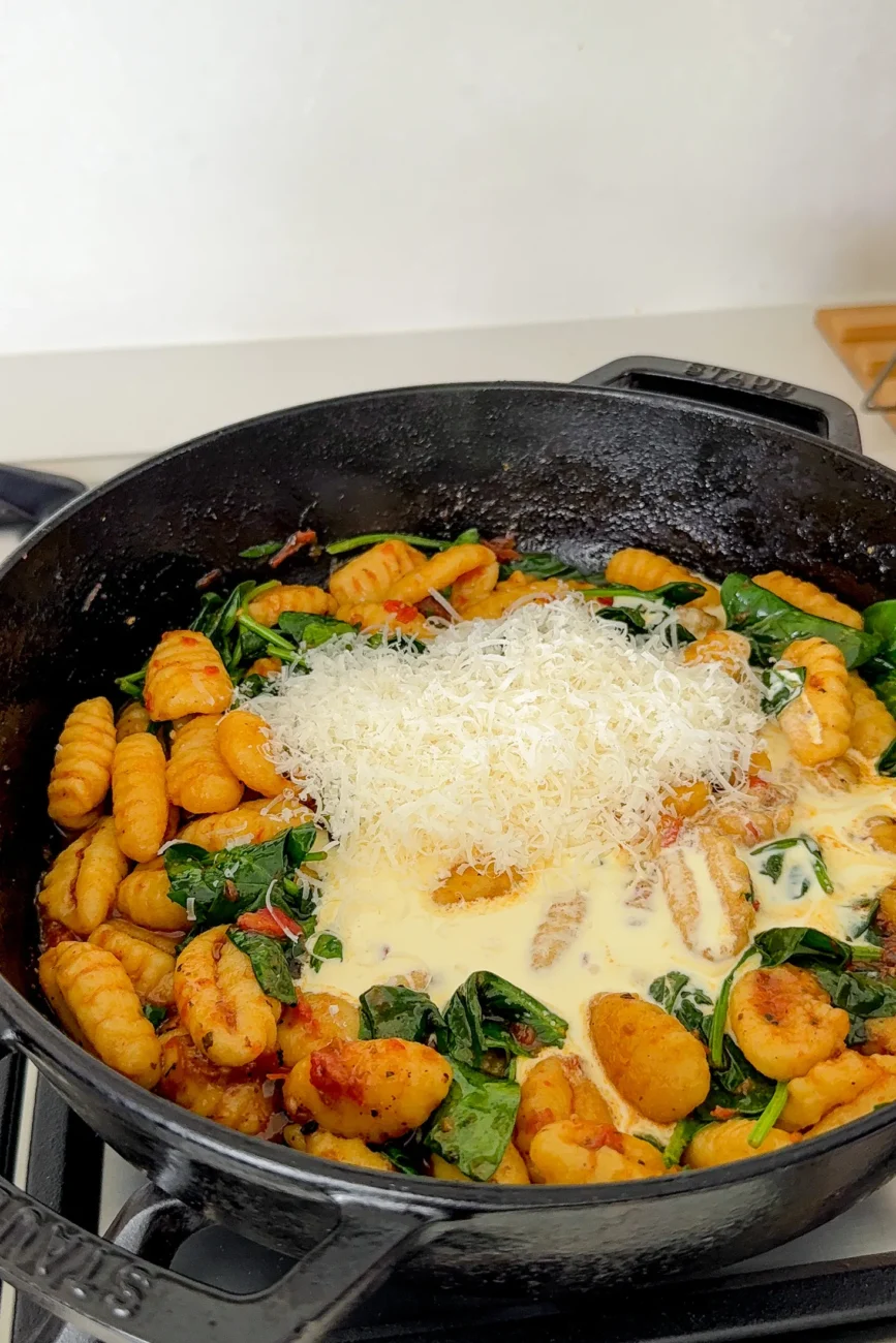 Adding cream and parmesan to pan
