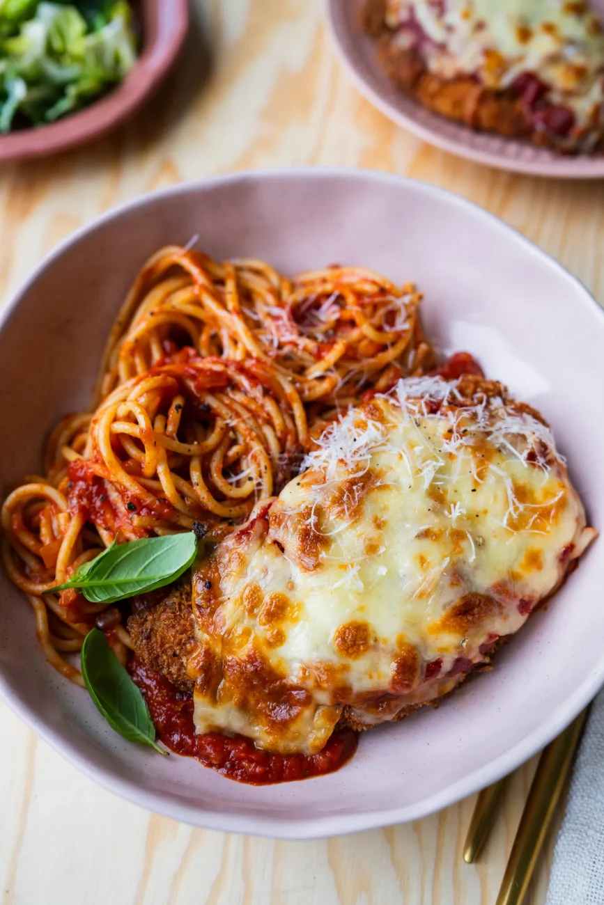 Chicken parmigiana plated with spaghetti