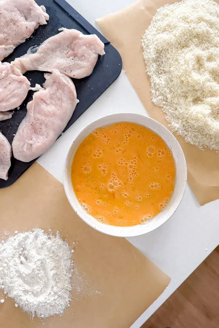 Crumbing station set up with flour eggs and parmesan breadcrumbs