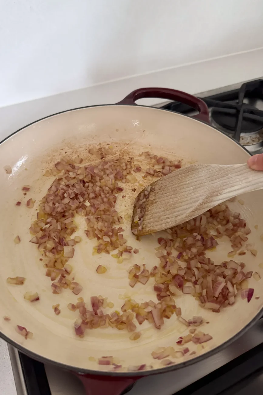 Red onion sautรฉing in pan for tomato and basil sauce
